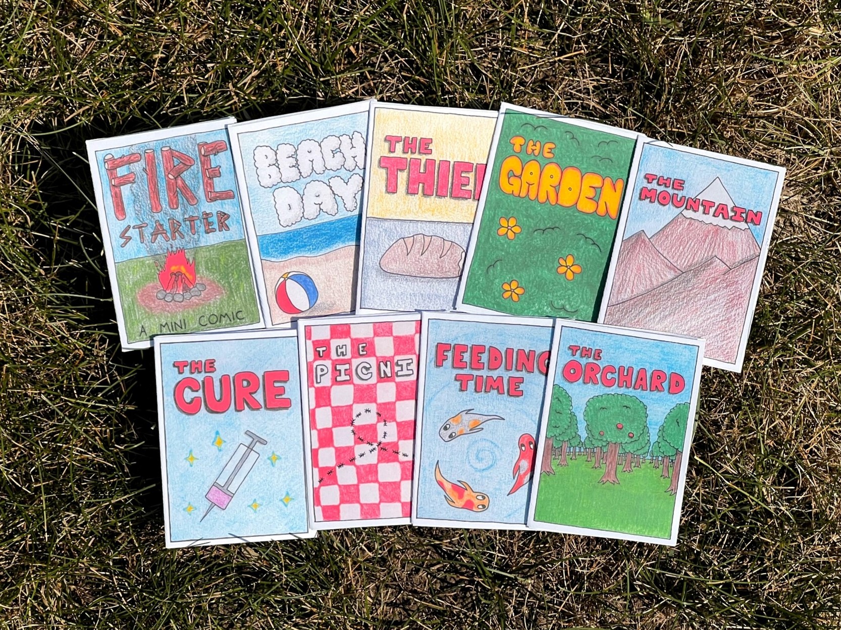 Nine Bugnut mini comics fanned out on grass